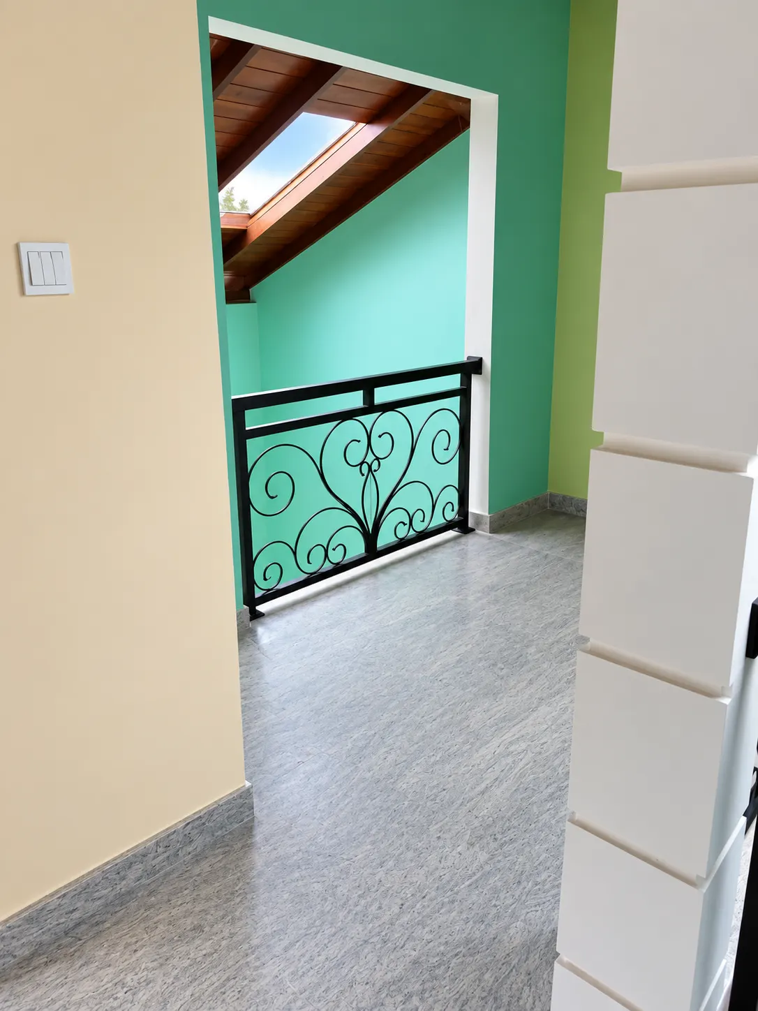 Scroll balcony railing against a teal wall